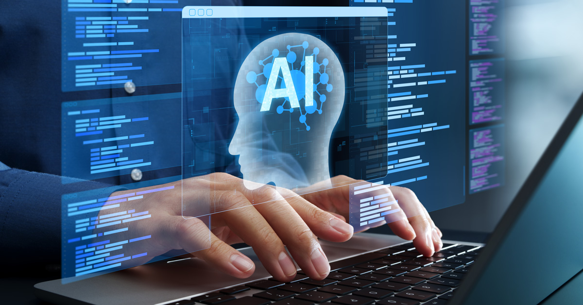 A man working on a laptop with a holographic AI head hovering over his laptop.