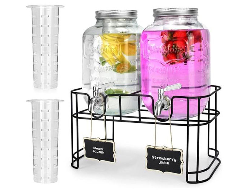 A double beverage dispenser set featuring two large mason jars on a black metal stand, filled with clear lemon water and pink strawberry juice, complete with hanging chalkboard labels and two detachable plastic infusion cylinders on the side.