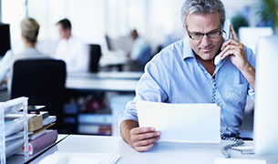 Image Businessman on a call and reviewing a claim.