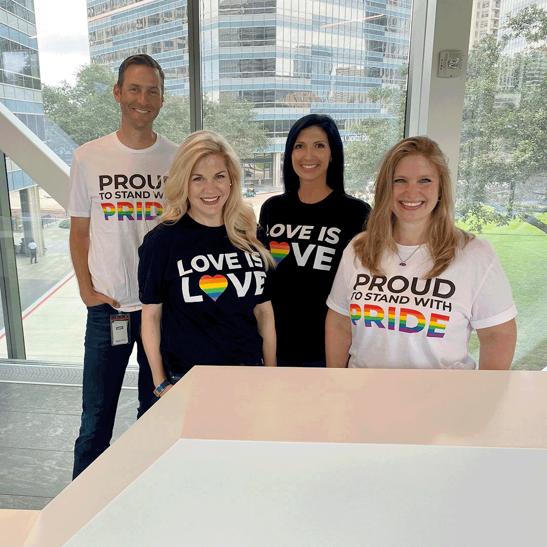Stewart employees posing on the sky bridge wearing pride month shirts. 