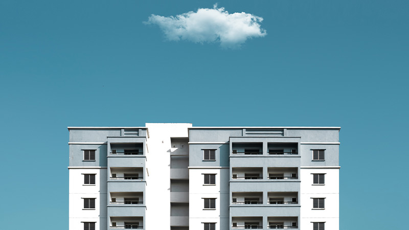 Image Top four floors of a condominium with a white cloud hovering above