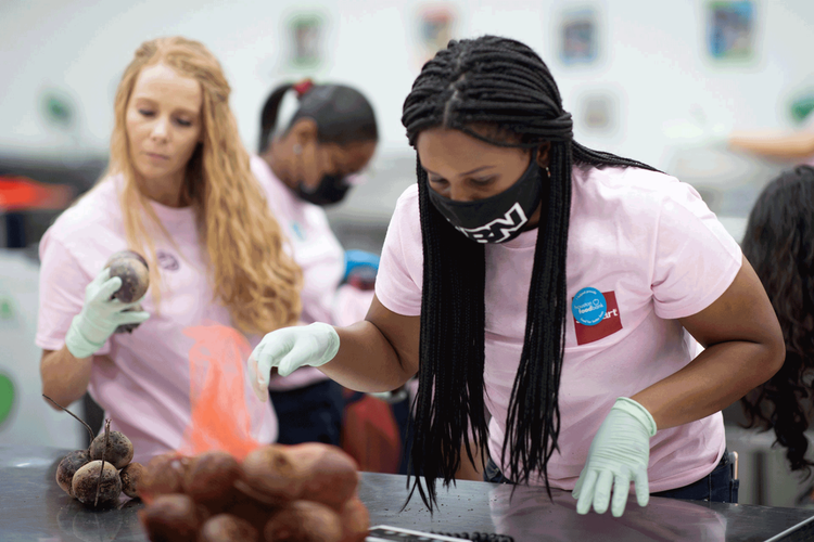 Two Stewart employees weigh and inspect produce at local food bank.