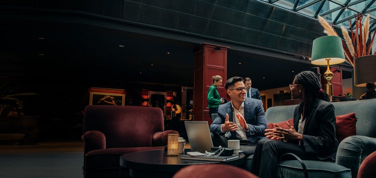 Two young business professionals meet in a hotel lobby