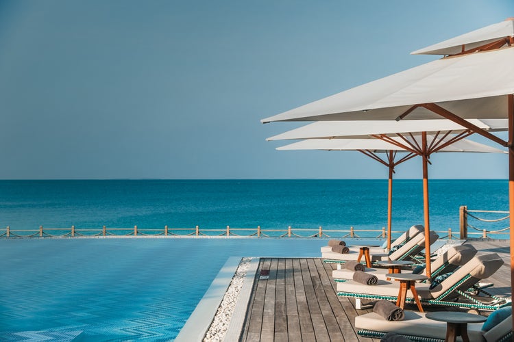 Tropical pool with lounges that overlook the ocean