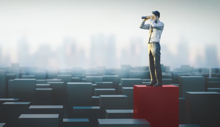 Businessman with binoculars overlooks a landscape of graphs