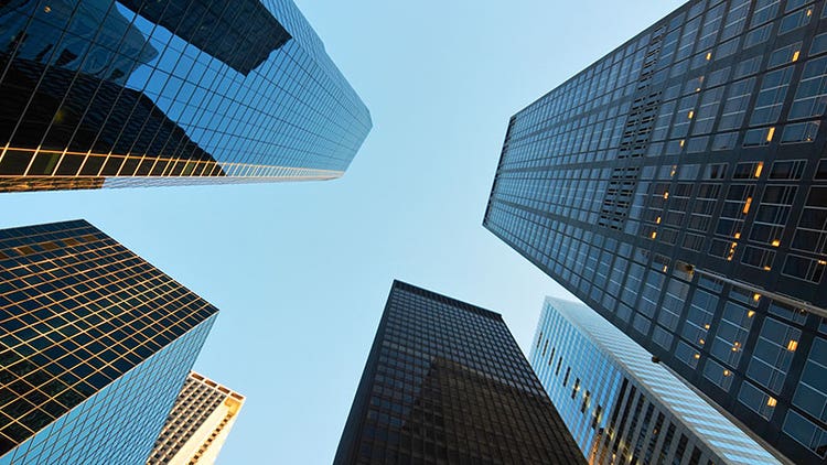 Glass skyscrapers tower above from a ground perspective.