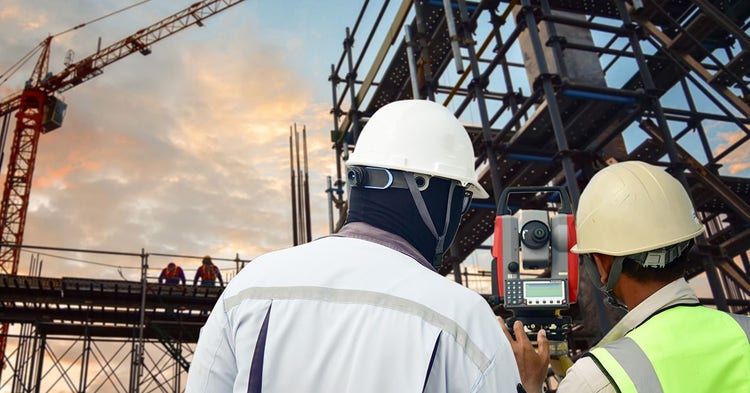 Two surveyors at a commercial construction site.