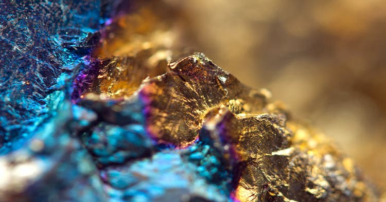 Close up of raw gold metal adjoined to an aqua blue metal ore