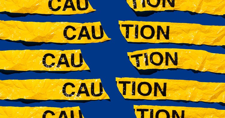Broken yellow caution tape gainst blue background