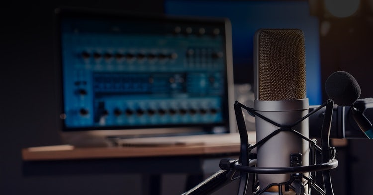 Dimly lit recording studio with microphone in the foreground