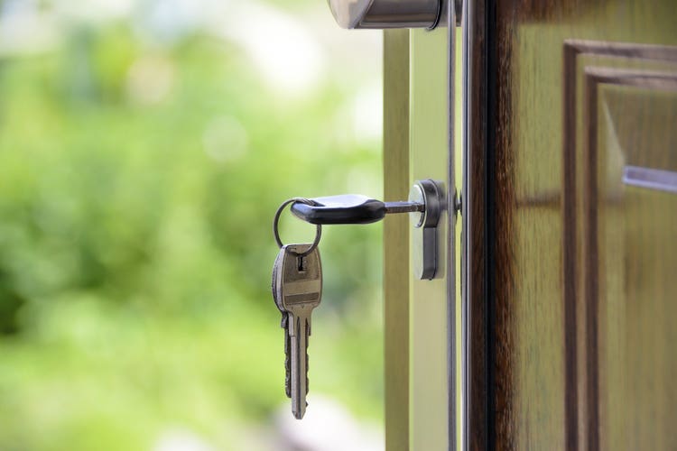 Image Key inserted into a front door of a home.