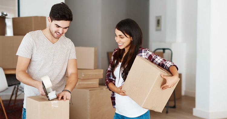 Young couple pack moving boxes
