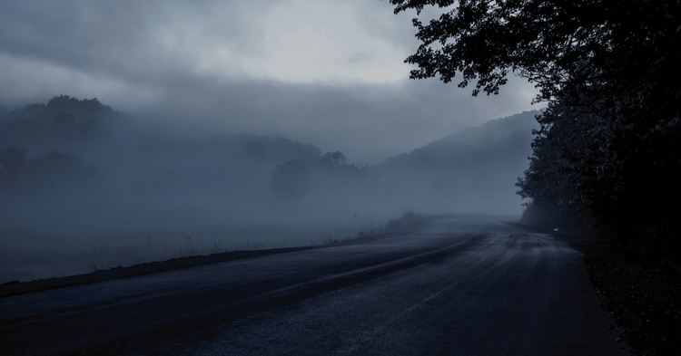Dirt road overlooking a rural foggy landscape at dusk