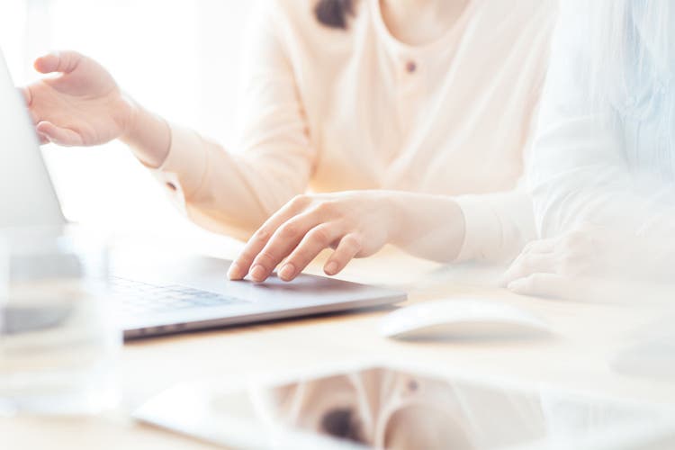 Hands of a woman working on a laptop