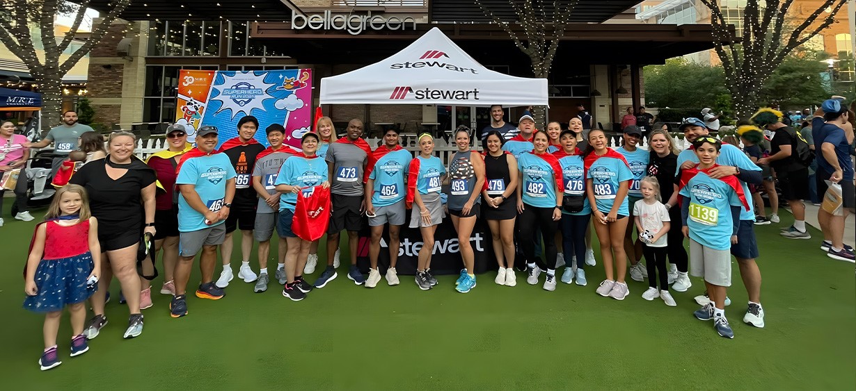 Un grupo de empleados de Stewart en un evento benéfico temático de superhéroes