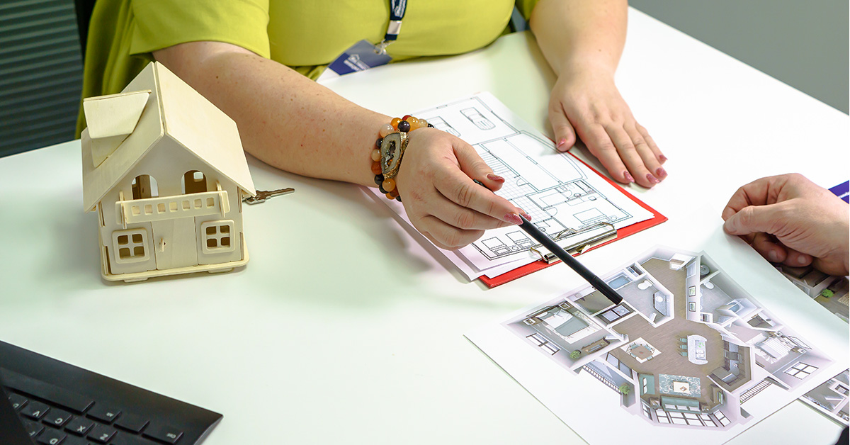 Dos personas revisando un plano de planta residencial.