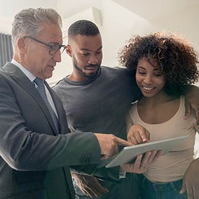 Image Real estate agent showing a property to a happy African American couple using a tablet computer â lifestyle concepts