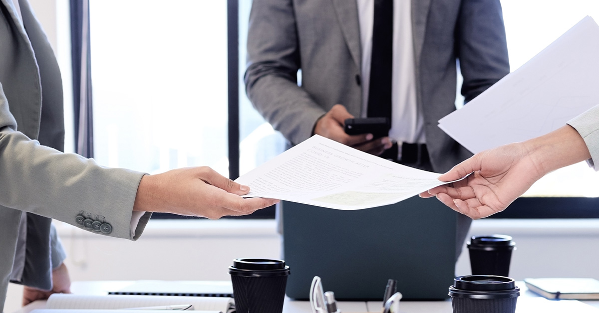 Tài liệu thay đổi tay trong cuộc họp kinh doanh gồm ba người